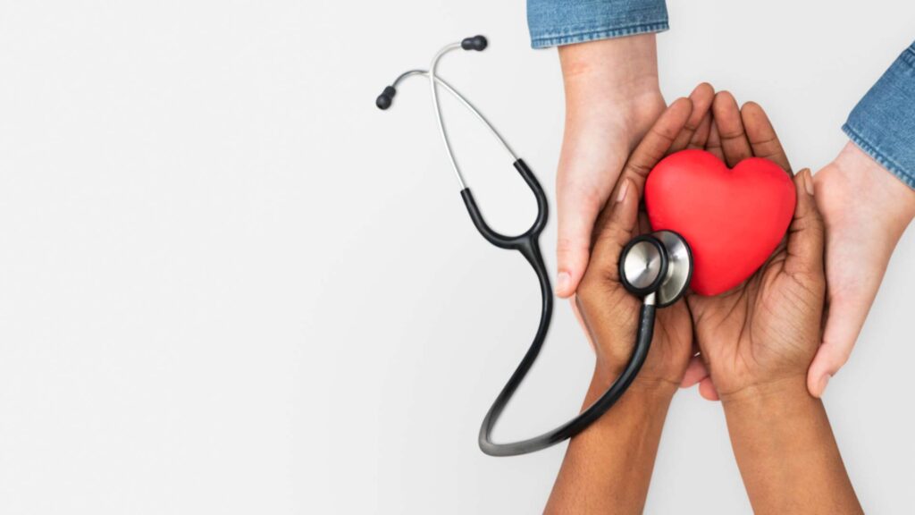 hands holding stethoscope and a heart
